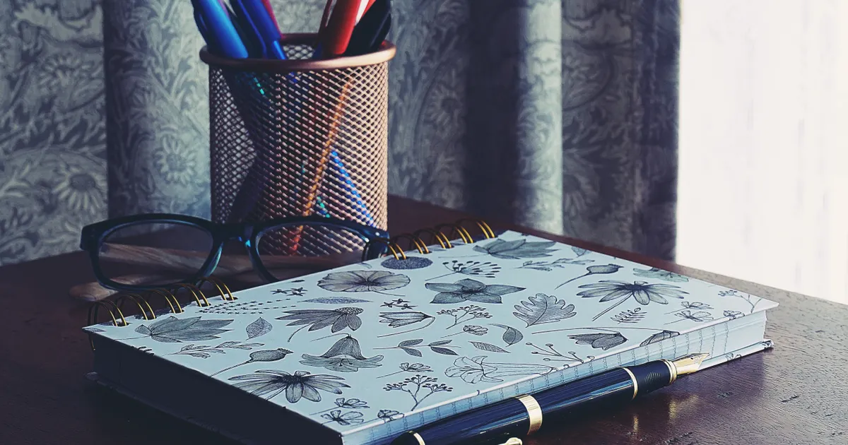 Un carnet et un stylo sur un bureau de travail, en illustration de la section « Où passe vraiment la limite : l'échelle, pas l'outil »