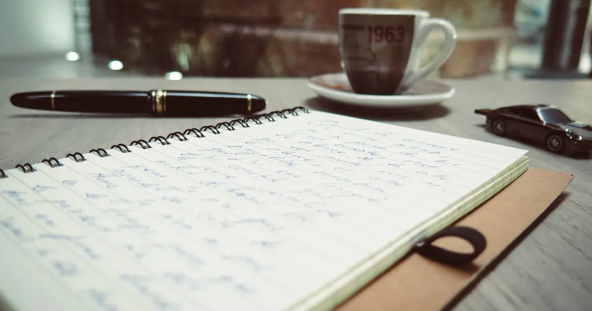 Un carnet et un stylo sur un bureau de travail, en illustration de la section « Trouver les pages qui valent l'effort »