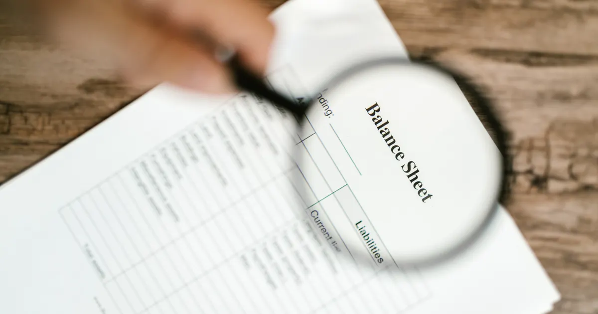 Une loupe posée sur un document imprimé, en illustration de la section « N'ignorez pas la visibilité dans les IA (GEO) »