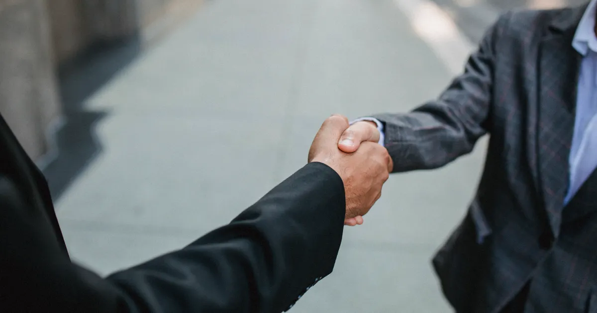 Deux personnes se serrant la main sur un accord, en illustration de la section « Reconduction, préavis et porte de sortie »