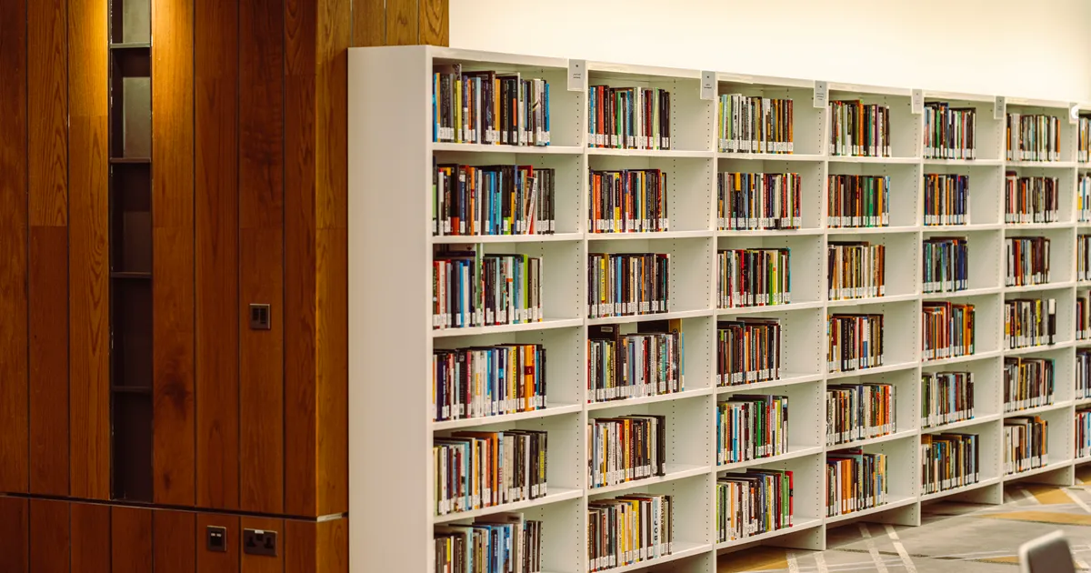 Des rangées d'ouvrages de référence sur les étagères d'une bibliothèque, en illustration de la définition SEO de CPC (coût par clic)