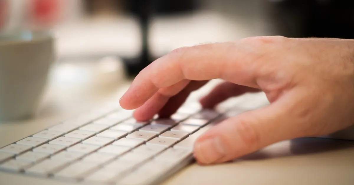 Des mains qui tapent sur un clavier, en illustration de la définition SEO de E-E-A-T