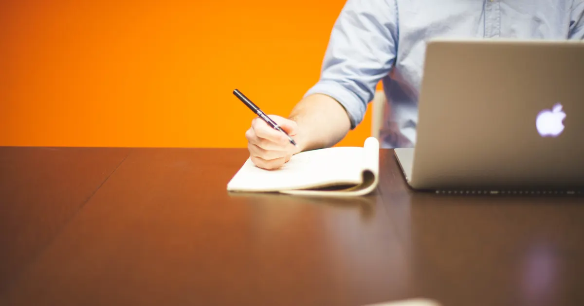 Un carnet et un stylo sur un bureau de travail, en illustration de la définition SEO de Cannibalisation de mots-clés