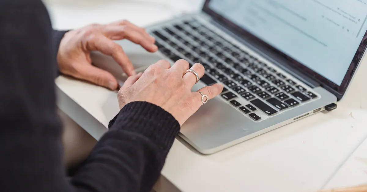 Une personne qui travaille seule sur un ordinateur portable, en illustration de la définition SEO de SERP (page de résultats)