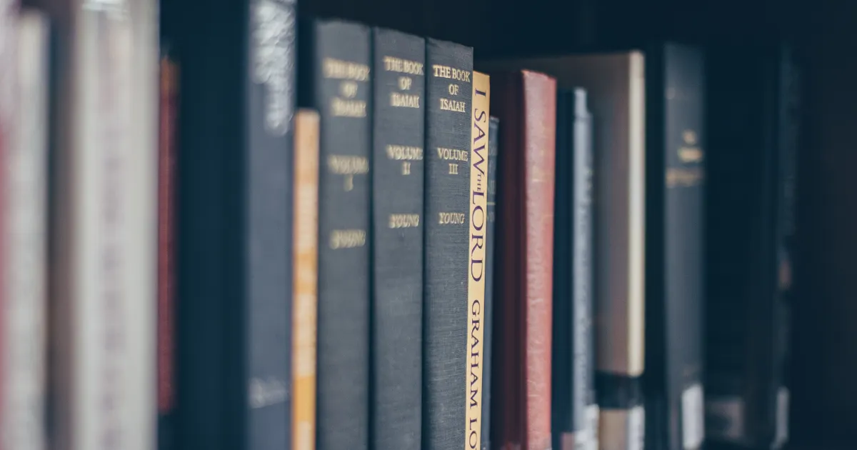 Des rangées d'ouvrages de référence sur les étagères d'une bibliothèque, en illustration de la définition SEO de Balise title