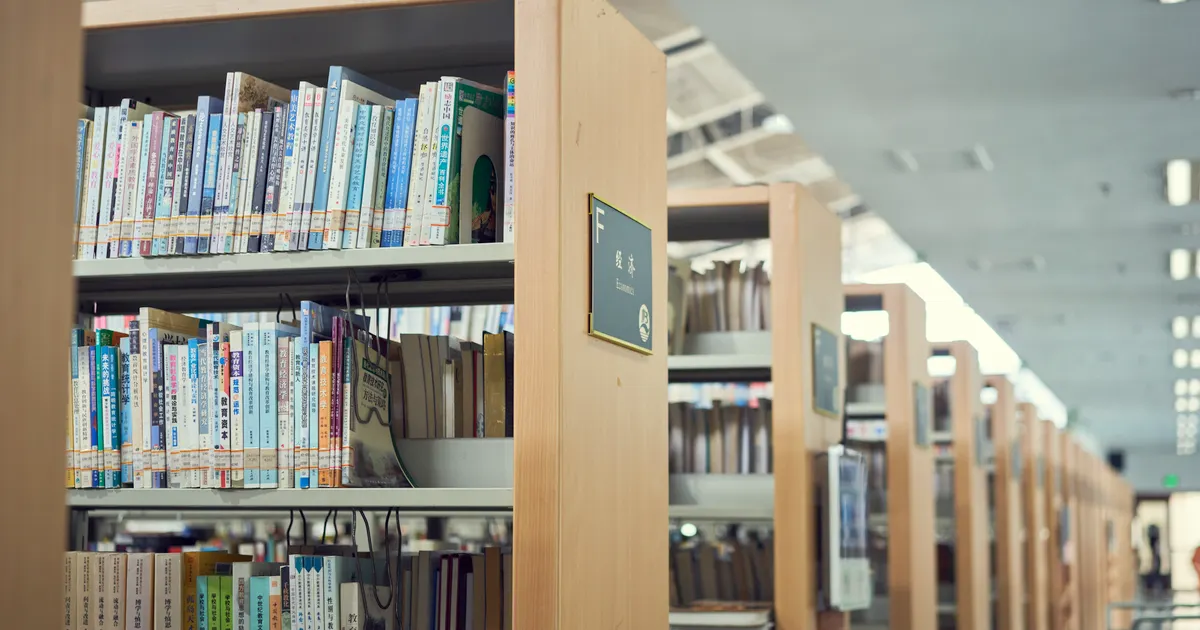 Des rangées d'ouvrages de référence sur les étagères d'une bibliothèque, en illustration de le glossaire SEO & GEO